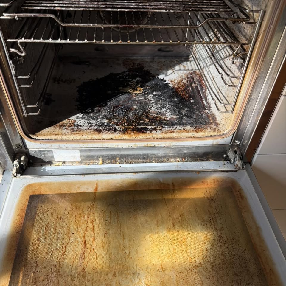 Oven interior with heavy burnt-on grease and stained door glass before cleaning