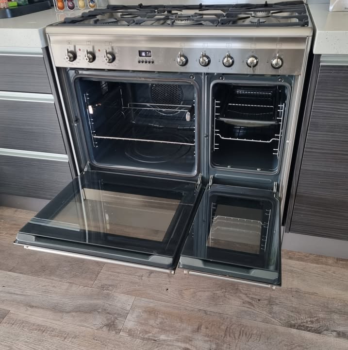 Spotlessly cleaned stainless dual-cavity range cooker with both oven doors open, Kim's signature result